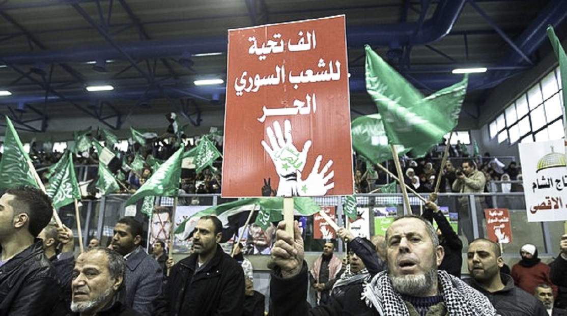 An Arab Israeli man holds a placards during a rally against the Syrian regime in the northern Arab-Israeli village of Kfar Kana | Pic Credit: Freedom House @Flickr.com